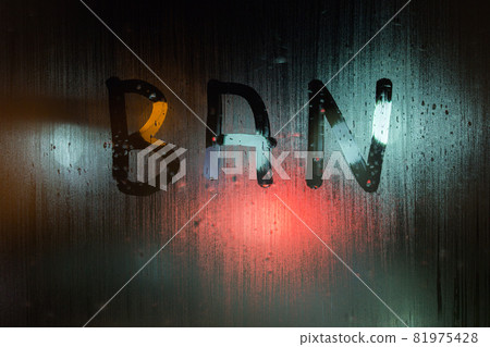 the word ban written on night wet window glass close-up with bokeh background 81975428