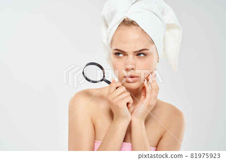 woman with bare shoulders with a magnifying glass in her hands black dots on her face woman with bare shoulders with a magnifying glass in her hands black dots on her face 81975923