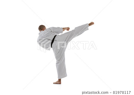 Back view. Full-length portrait of caucasian sportsman standing in side kick pose isolated over white background. Karate, judo, taekwondo sport Back view. Full-length portrait of caucasian sportsman standing in side kick pose isolated over white background. Karate, judo, taekwondo sport 81978117