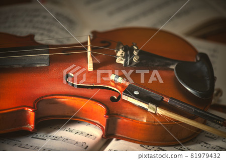 Violin and bow resting on sheet music Violin and bow resting on sheet music 81979432