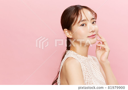 粉紅色背景中穿著裙子的年輕女子的美麗肖像 粉紅色背景中穿著裙子的年輕女子的美麗肖像 81979900