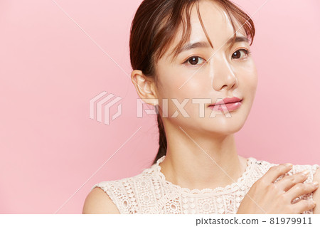 粉紅色背景中穿著裙子的年輕女子的美麗肖像 粉紅色背景中穿著裙子的年輕女子的美麗肖像 81979911