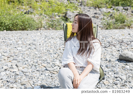 女孩坐在營地的椅子上 81983249