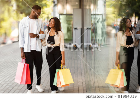 Fulll body length of black couple walking with shopping bags Fulll body length of black couple walking with shopping bags 81984319