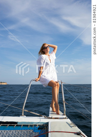 young woman drinking champagne on a yacht in the open sea young woman drinking champagne on a yacht in the open sea 81984921