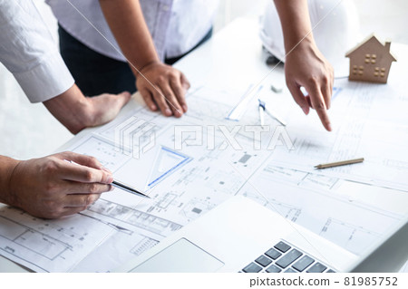 Construction engineering or architect discuss a blueprint while checking information on drawing and sketching meeting for architectural project in work site 81985752