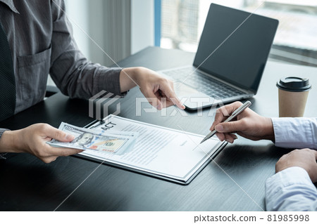 Man employee giving bribe money to business woman and pointing at the contract signing box 81985998