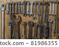 Set of wrenches tools hanging on a wall 81986355