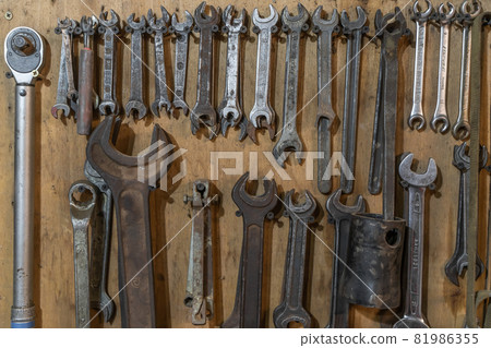 Set of wrenches tools hanging on a wall 81986355
