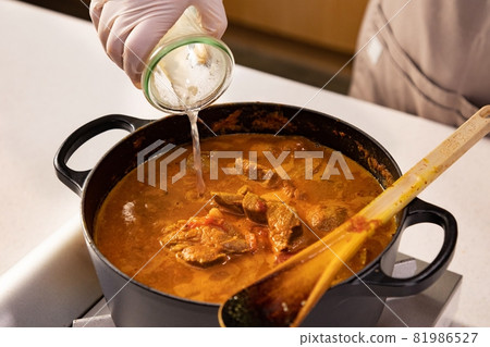 Hands pouring water in beef soup at the kitchen Hands pouring water in beef soup at the kitchen 81986527