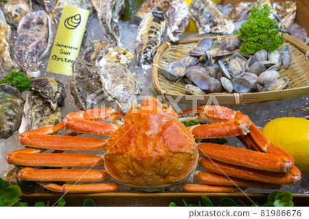 fresh red snow crab, japanese sun oysters and other seafood display on ice in the stall at tsukiji fish market in japan. Tsukiji fish market is largest wholesale fish and seafood market in the world. fresh red snow crab, japanese sun oysters and other seafood display on ice in the stall at tsukiji fish market in japan. Tsukiji fish market is largest wholesale fish and seafood market in the world. 81986676
