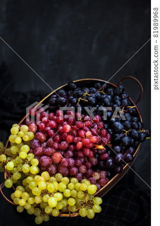 White, red and black fresh autumn grapes on dark background, top view 81989968