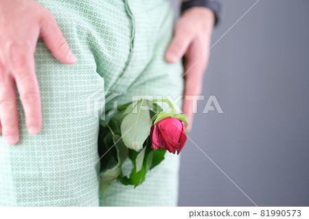 Withered rose flower sandwiched between man legs closeup 81990573
