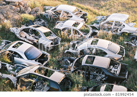 Top view of the car graveyard. Broken old rusty cars lying on the grass 81992454