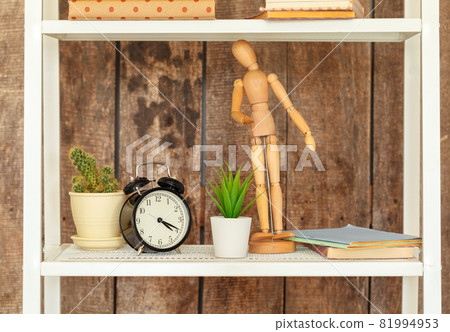 Close up of white bookshelf against grunge wooden wall Close up of white bookshelf against grunge wooden wall 81994953