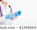 A young nurse in a mask opens a syringe on a white background in a white coat, to make a vaccination 81998660