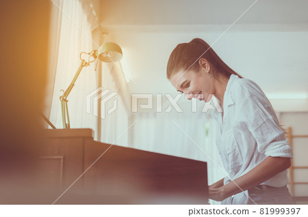 Beautiful caucasian young woman playing electronic piano,Happy and smiling,Relaxing time 81999397