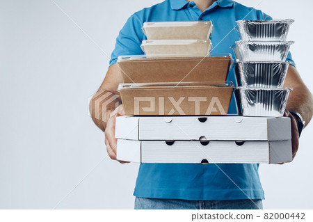 Unrecognizable man in blue polo with food delivery orders against grey background 82000442