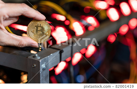 Hand holding bitcoin on Bitcoin mining farm background Hand holding bitcoin on Bitcoin mining farm background 82001419