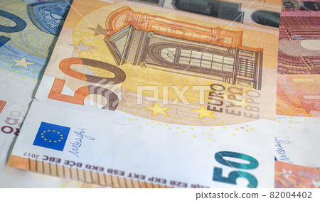 Fragment part of 50 euro banknote close-up with small brown details. Closeup of the fifty euro banknote, Euro currency money. Oblique detailed macro view. New Europe paper money. European Union cash Fragment part of 50 euro banknote close-up with small brown details. Closeup of the fifty euro banknote, Euro currency money. Oblique detailed macro view. New Europe paper money. European Union cash 82004402