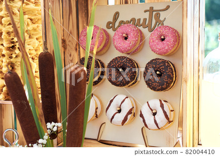 Donuts hanged on a board Delicious donuts in colored glaze 82004410