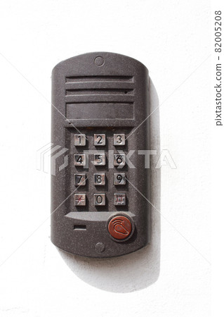 Gray metal intercom device on white concrete building wall with shadow Gray metal intercom device on white concrete building wall with shadow 82005208