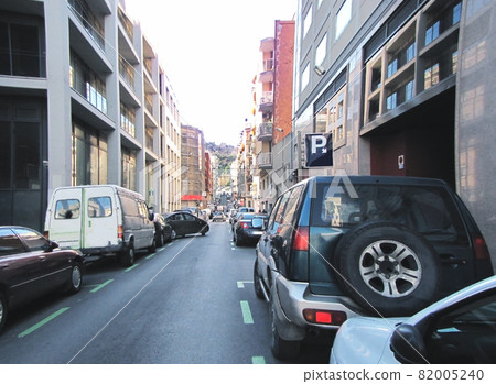 One way city street filled with parked cars, no sidewalk One way city street filled with parked cars, no sidewalk 82005240