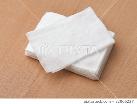 Stack of unwrapped wet wipes on wooden table 82006227