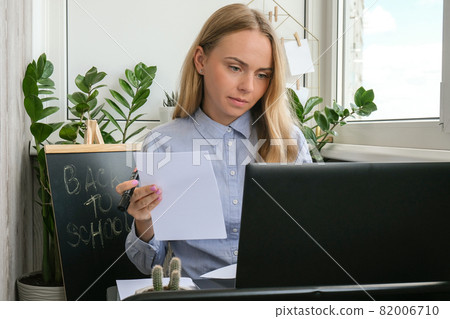 Young female teacher sitting at desk and using laptop at home. e Education Back to school. Student learning online class. Distance learning. Exam preparation Young female teacher sitting at desk and using laptop at home. e Education Back to school. Student learning online class. Distance learning. Exam preparation 82006710