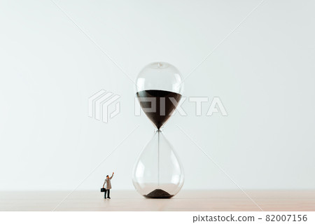 Lonely businessman and giant snad clock. Business concept Lonely businessman and giant snad clock. Business concept 82007156