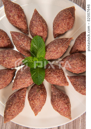 Traditional kebbe and pita bread on big round plate in lebanese restaurant 82007646