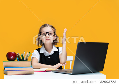 Caucasian schoolgirl raising hand sitting at laptop during online lesson. Distant School Learning. Caucasian schoolgirl raising hand sitting at laptop during online lesson. Distant School Learning. 82008728