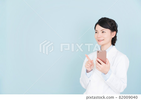 A woman in a lab coat operating a smartphone 82009040