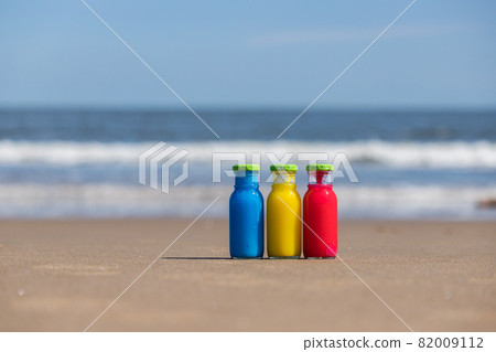 Landscape of colorful glass bottles on the sandy beach of the summer sea beach Landscape of colorful glass bottles on the sandy beach of the summer sea beach 82009112