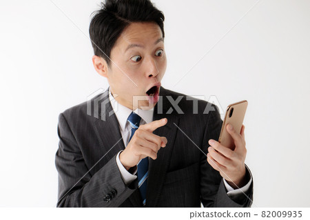 Businessman surprised smartphone middle man 82009935