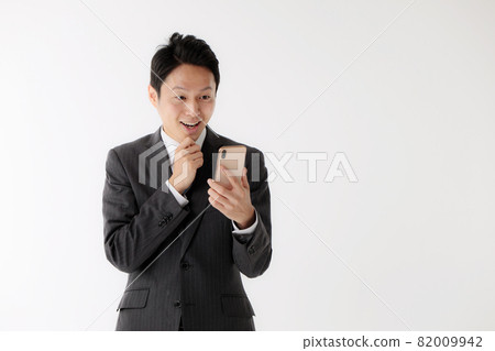 Businessman surprised smartphone middle man 82009942