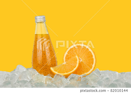 One glass bottle of orange drink on ice One glass bottle of orange drink on ice 82010144