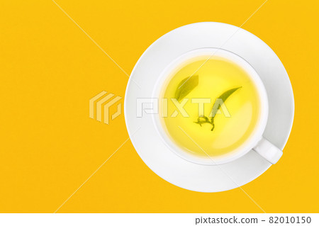 Cup of green oolong tea over yellow 82010150