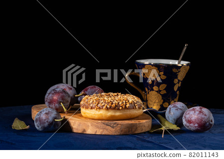 Donut cake with chocolate filling, sprinkled with nuts on a dark background Donut cake with chocolate filling, sprinkled with nuts on a dark background 82011143