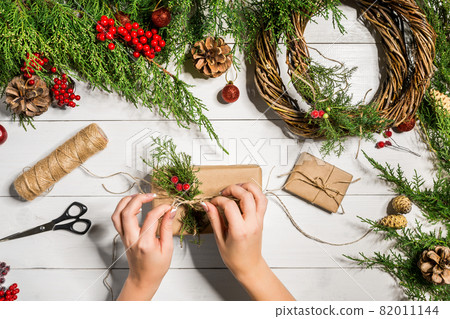 Christmas gift decoration with handmade DIY on a white wooden background. Do it by yourself. Christmas gift decoration with handmade DIY on a white wooden background. Do it by yourself. 82011144