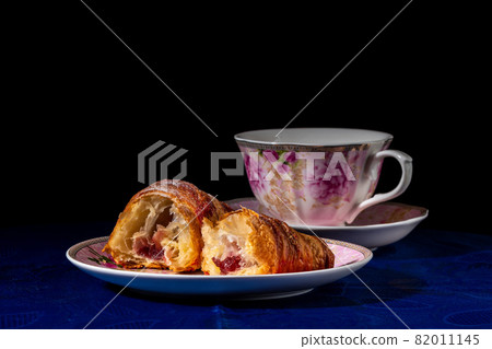 Croissant with strawberry filling on a dark background Croissant with strawberry filling on a dark background 82011145