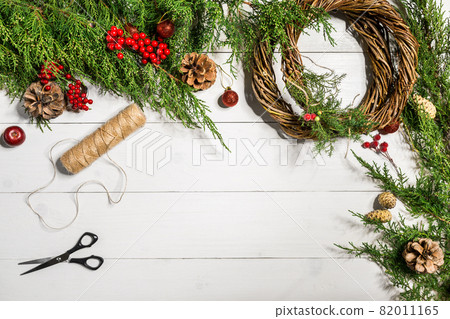 Make a Christmas wreath with your own hands. Spruce branch, Christmas wreath and gifts on a white wooden background Make a Christmas wreath with your own hands. Spruce branch, Christmas wreath and gifts on a white wooden background 82011165