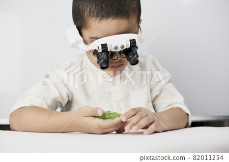 A little boy exploring slime structure with head magnifying glasses headset A little boy exploring slime structure with head magnifying glasses headset 82011254