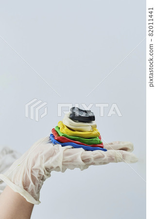 A boy holding a handmade pyramid made with plasticines of different colors A boy holding a handmade pyramid made with plasticines of different colors 82011441