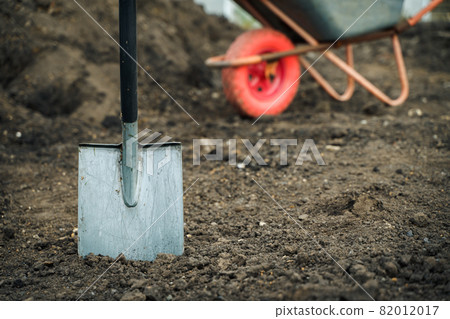 Working with garden tools, shovel and wheelbarrow on the site of a country house. Preparation for construction work. 82012017