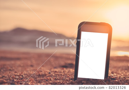 Smart phone on sand beach texture background. Smart phone on sand beach texture background. 82013326