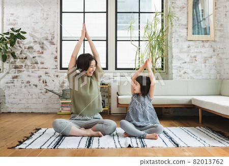 Parents and children doing yoga together at home 82013762