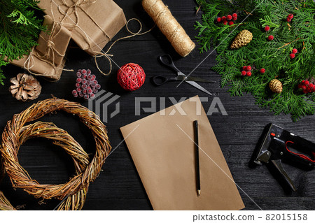 Packed gifts and scrolls, spruce branches and tools on wooden table. Packed gifts and scrolls, spruce branches and tools on wooden table. 82015158