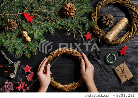 Manufacturer of Christmas decor with their own hands. Christmas wreath for the holiday. The new year celebration. Top view Manufacturer of Christmas decor with their own hands. Christmas wreath for the holiday. The new year celebration. Top view 82015281