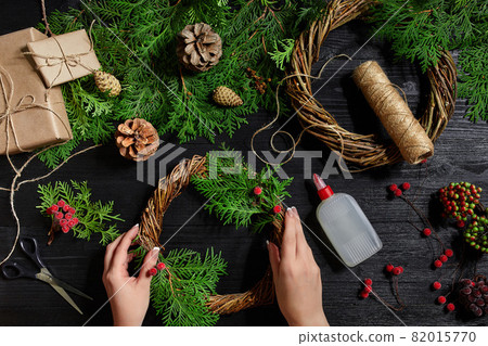 Manufacturer of Christmas decor with their own hands. Christmas wreath for the holiday. The new year celebration. Top view Manufacturer of Christmas decor with their own hands. Christmas wreath for the holiday. The new year celebration. Top view 82015770